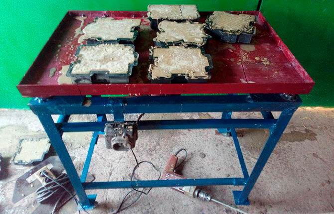 Vibrating table with molds for tiles