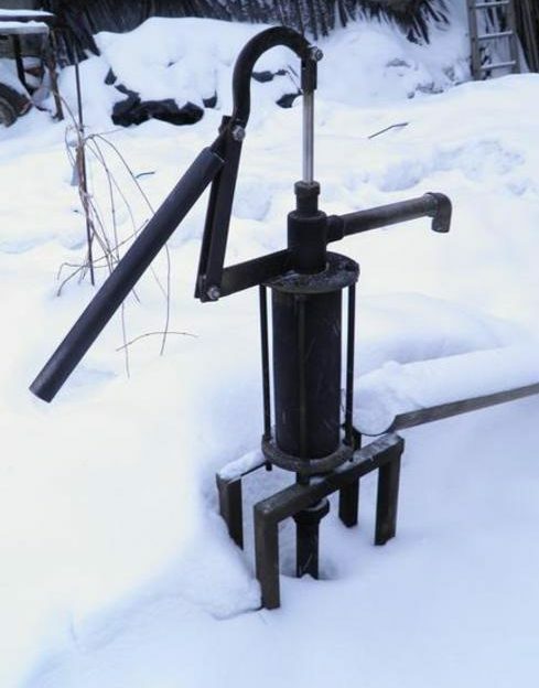 Metal hand pump in winter