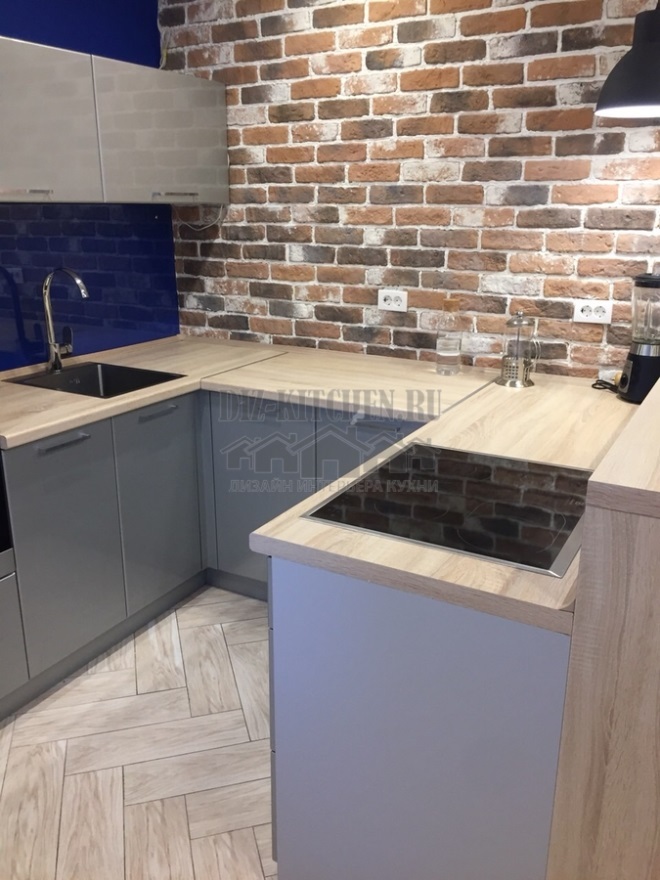 Grå og blå moderne køkken med accent murstensvæg