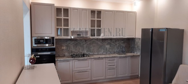 Kerge neoklassikaline sirge köök marmorist backsplashiga