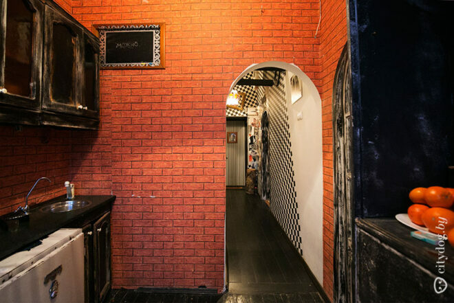 Design of a 7 sq.m black kitchen in a loft style with a real hatch in the floor