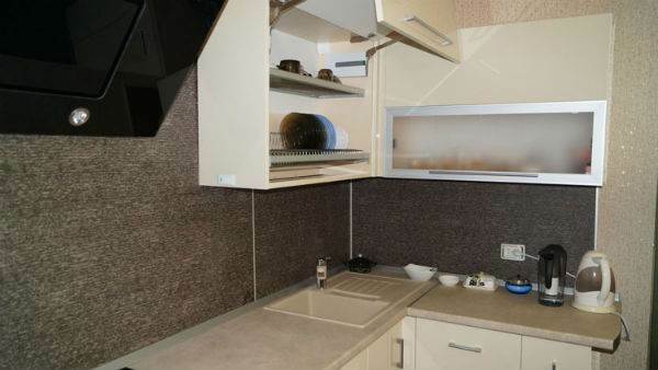 Moodne valge köök musta õhupuhasti ja pliidiplaadiga