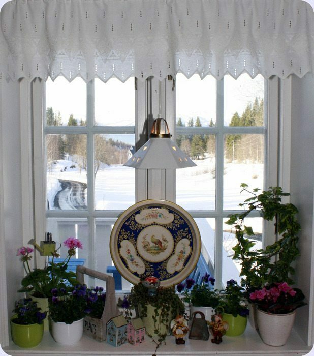 Dekoratīvie priekšmeti uz virtuves loga