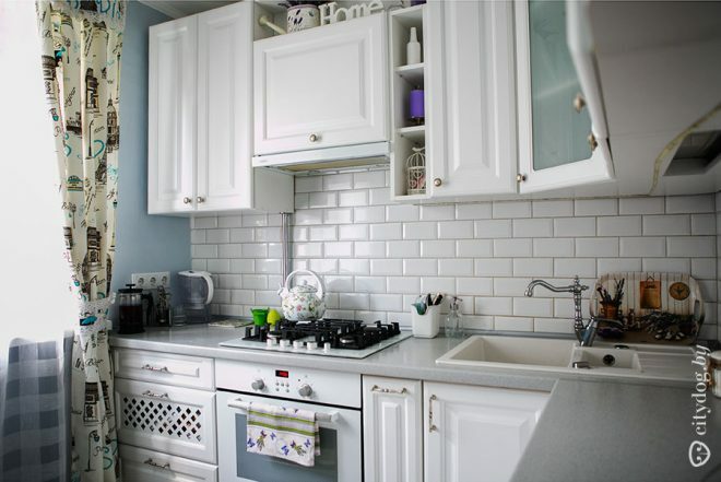 Mėlynos sienos ir maža balta Provanso stiliaus virtuvė