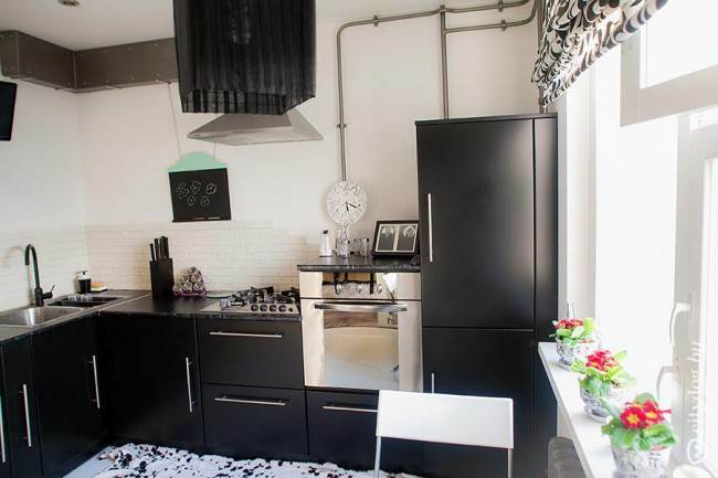 Black L-shaped kitchen without upper wall cabinets 9 m2