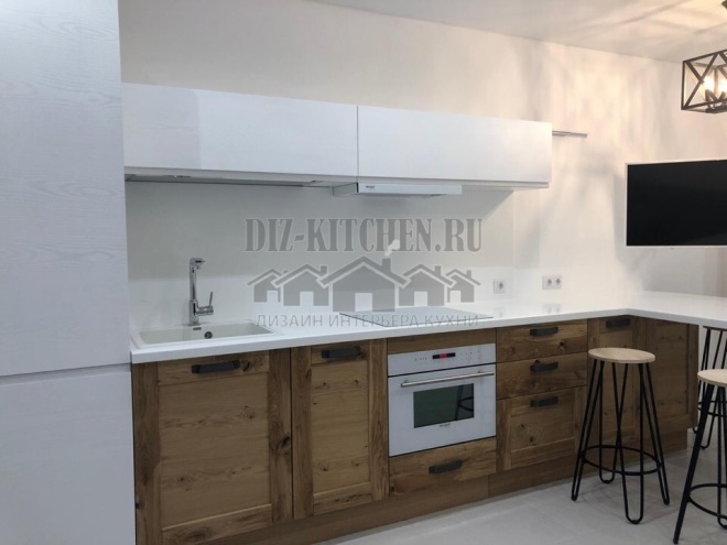 Modern kitchen made of white plastic and solid ash wood with a bar counter