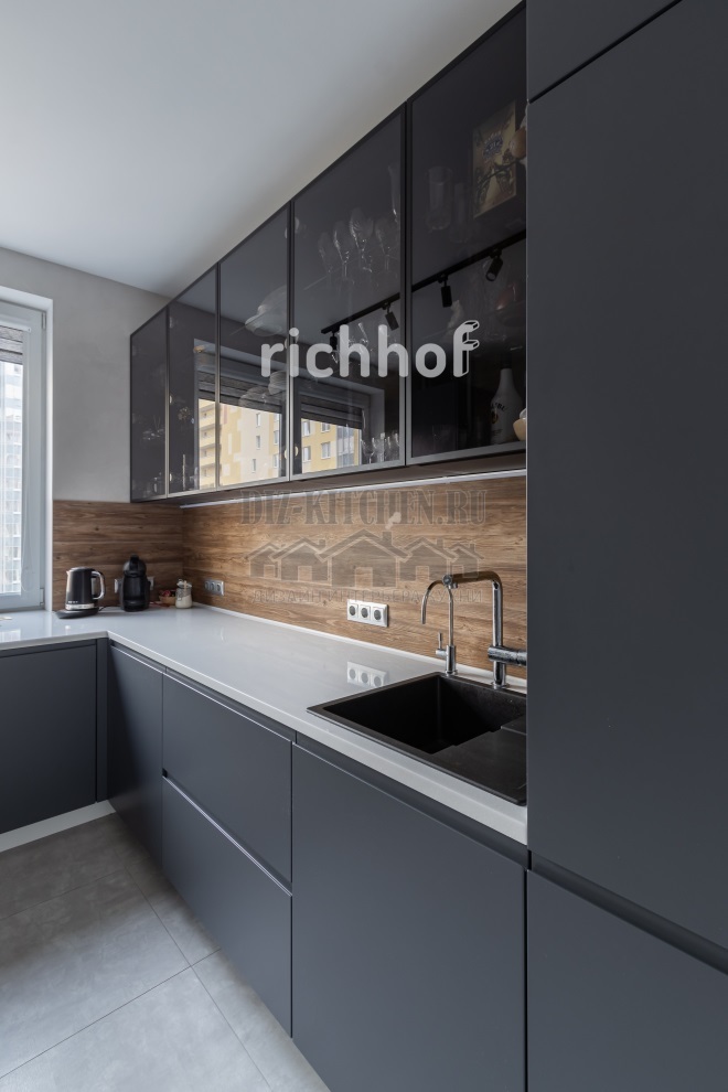 Cozinha moderna em cinza e preto com fogão sob a janela