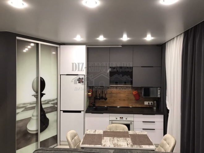 Minimalistisk hvitt og grått kjøkken i et bachelorstudio
