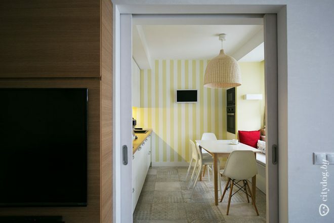 Dizajn kuchyne 10 m2. s bielou náhlavnou súpravou a pruhovanou tapetou