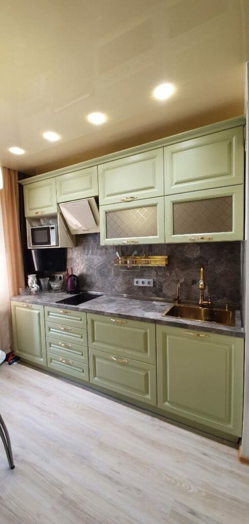 Olive kitchen with stone countertop and backsplash