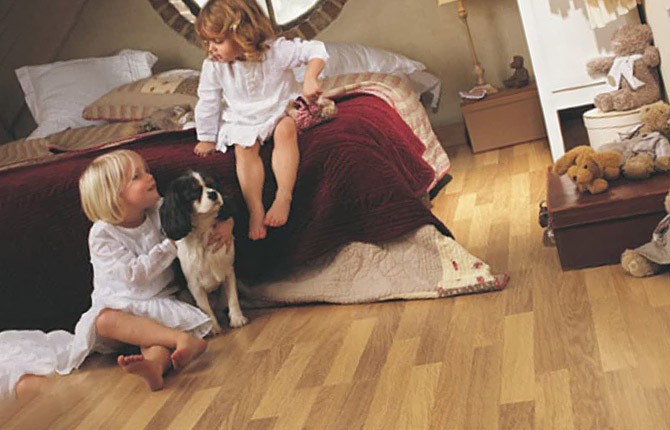 Niños en el suelo jugando con un perro.