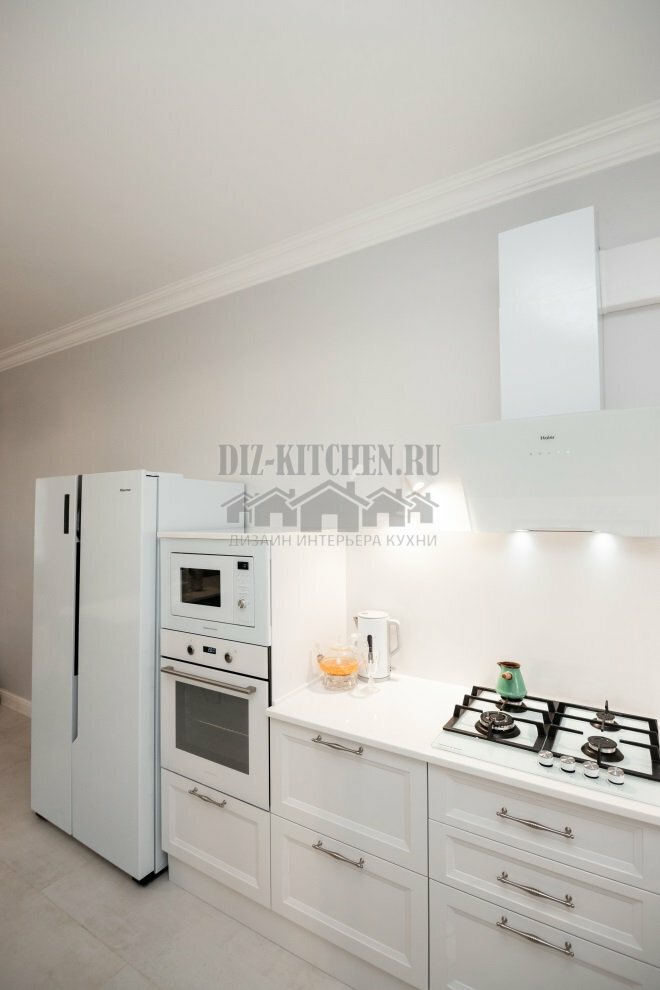 Weiße Küche ohne Oberschränke, kombiniert mit dem Wohnzimmer