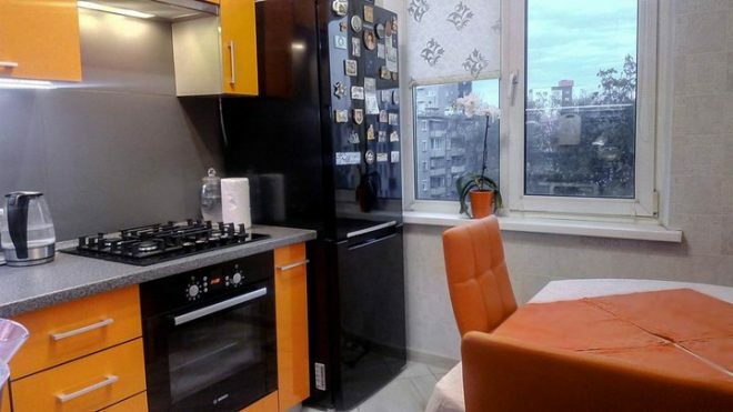 Oranža stūra virtuve ar apgaismojumu un ēdamistabas zonu