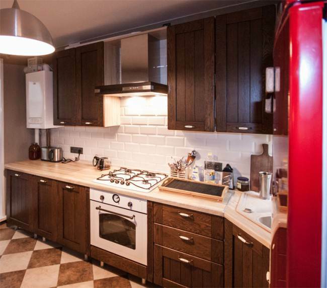 Stūra klasiska ozolkoka virtuve ar sarkanu ledusskapi